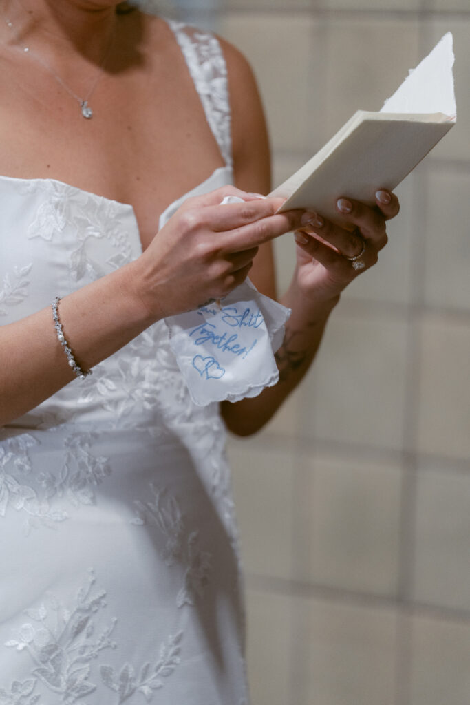 Bride reading handwritten vows during intimate Valentine’s Day wedding ceremony.