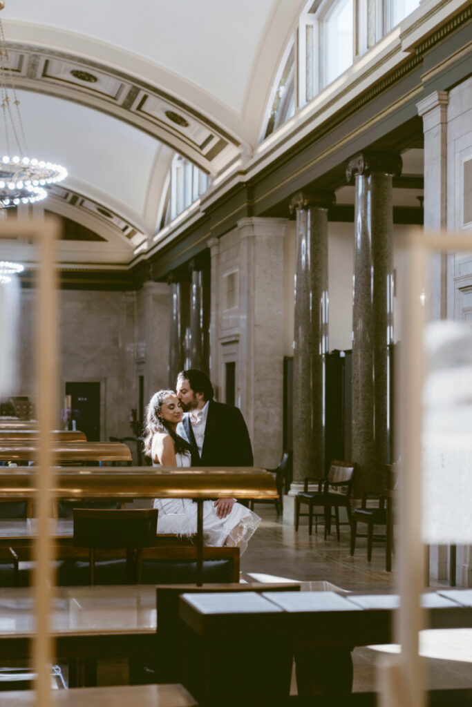 Bride and groom embracing inside courthouse during romantic Valentine’s Day wedding.