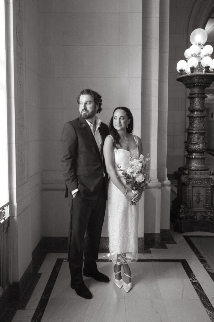 Bride and groom posing inside courthouse during elegant Valentine’s Day wedding.
