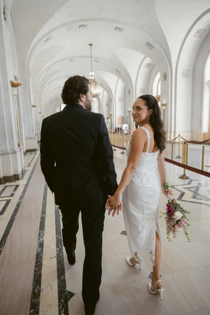 Couple walking hand in hand at their courthouse Valentine’s Day wedding.
