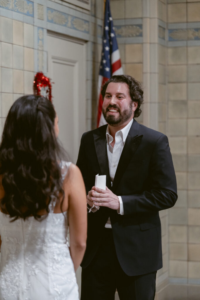 Groom smiling while reading vows at courthouse Valentine’s Day wedding.
