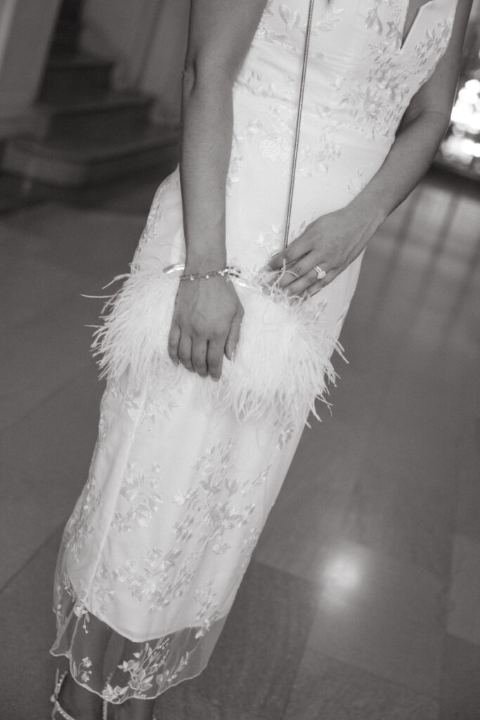 Black and white bridal detail with feather clutch at Valentine’s Day wedding.