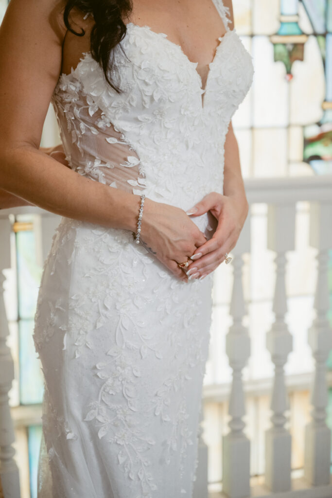 Close up of lace wedding dress bodice with floral detail.