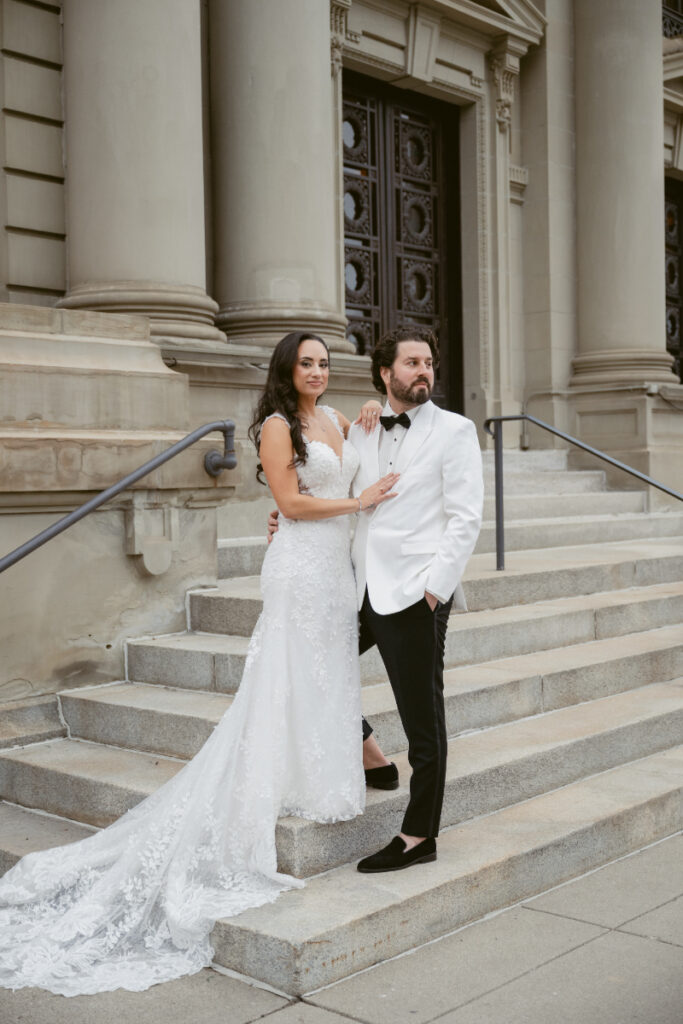 Bride and groom posing on courthouse steps after ceremony.