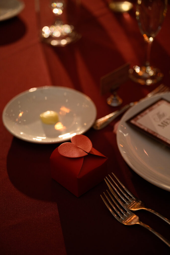 Close up of red wedding favor box on reception table.