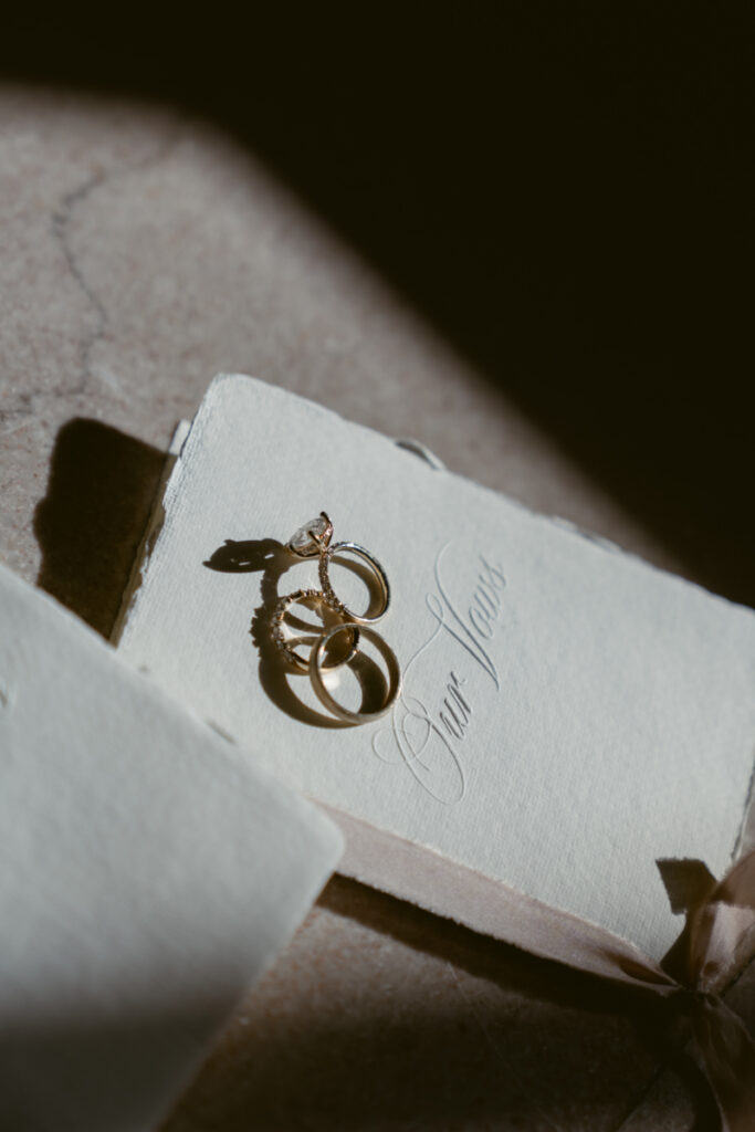Wedding rings resting on vow book during intimate Valentine’s Day wedding.