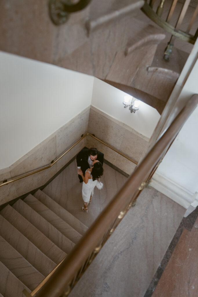 Overhead view of couple embracing on courthouse stairs during Valentine’s Day wedding.