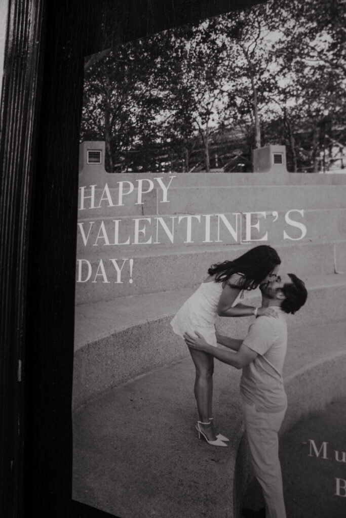 Black and white Valentine’s poster of couple kissing displayed at reception.