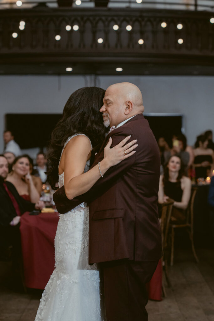 Bride sharing a dance with older male relative at reception.