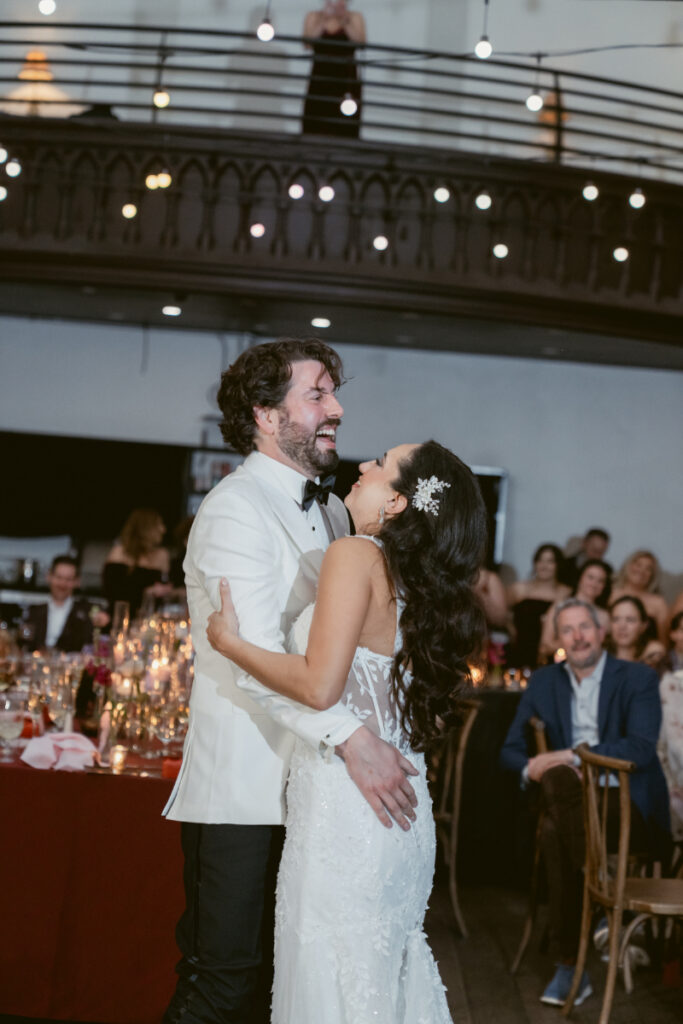 Bride and groom smiling during their first dance together.
