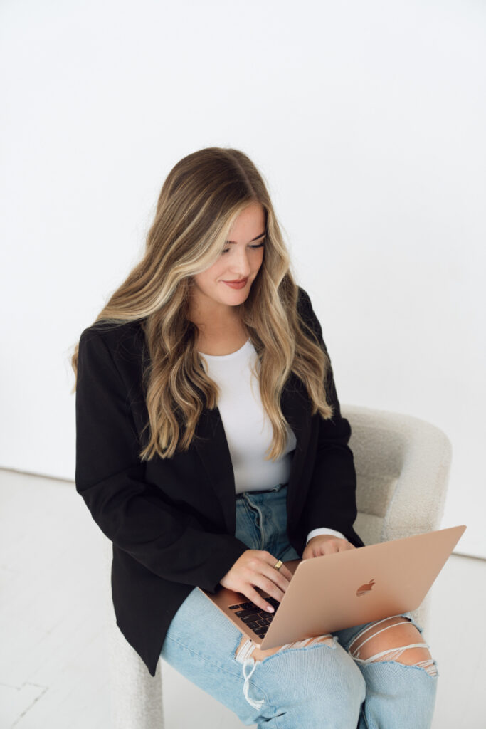 Cincinnati branding photography of professional woman working on laptop in modern office setting.