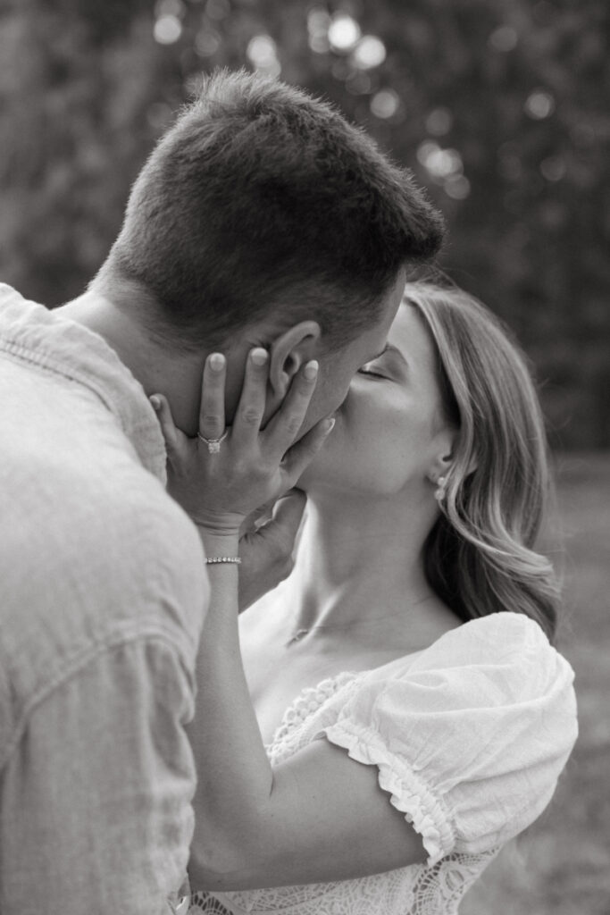 Close up of couple kissing with hands on face, soft black and white, intimate and emotional moment
