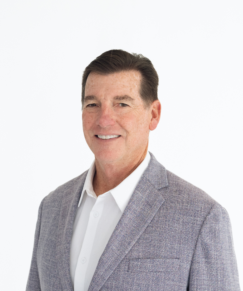 Professional photography headshots of smiling businessman in gray blazer, clean studio background.