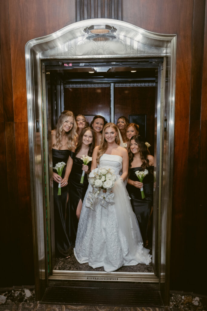 Bride walking forward with bridesmaids following behind her indoors.