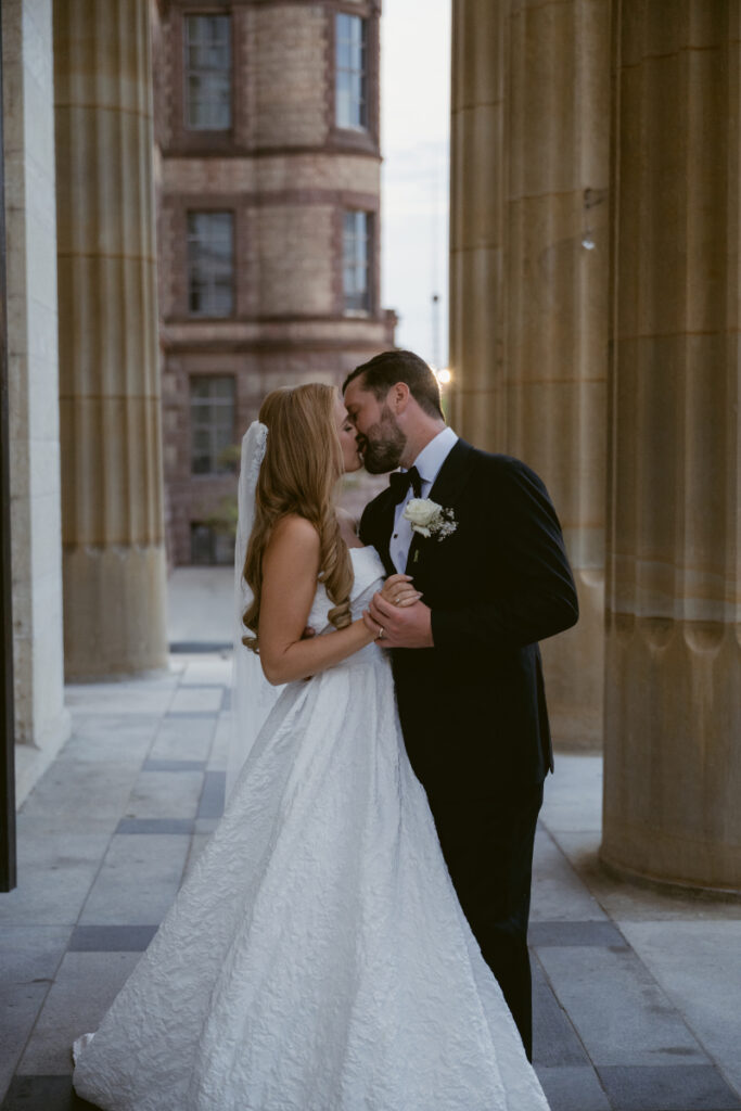 Bride and groom sharing a kiss during portraits outside the church.