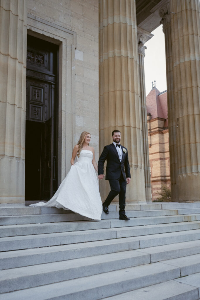 Bride and groom walking down the church steps together after the ceremony.