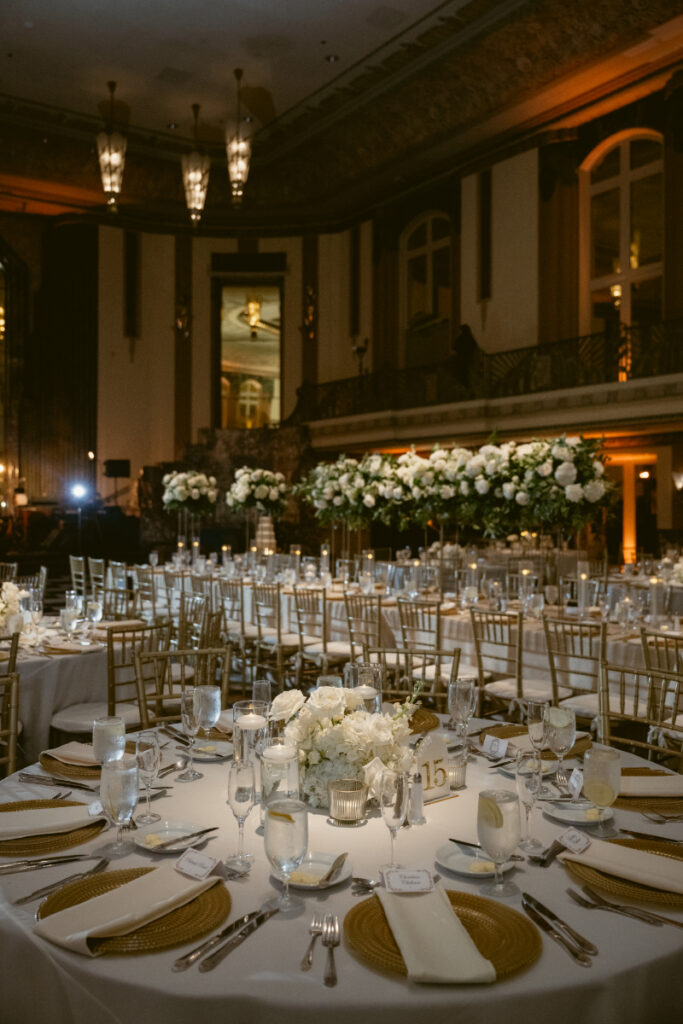 Reception space at night with candlelit tables and floral arrangements.