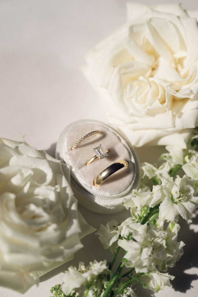 Wedding rings styled with white florals and velvet ring box during a Hilton Netherland Plaza wedding.