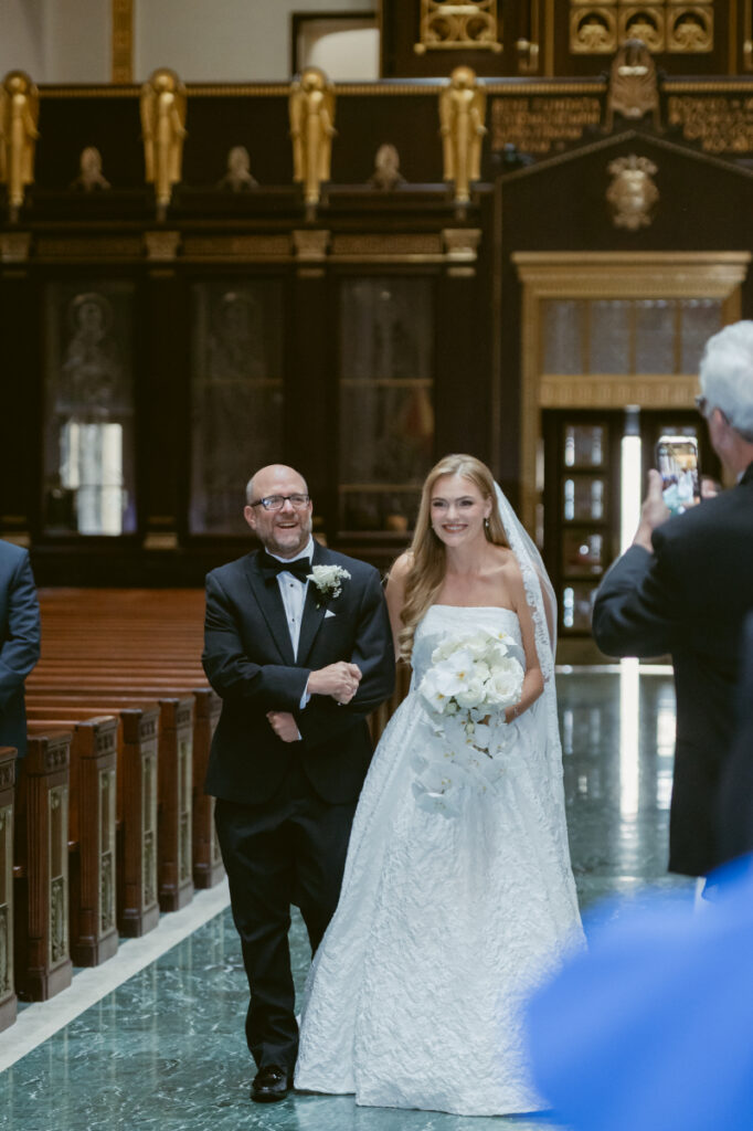 Bride walking down the aisle with a parent during the ceremony.