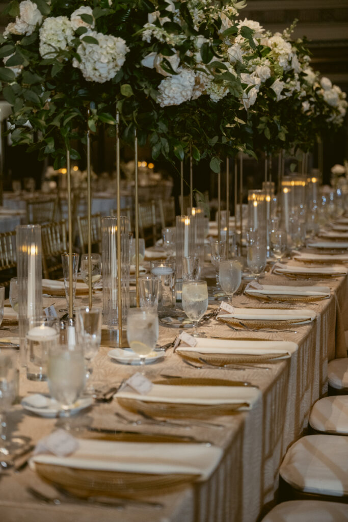 Reception tables styled with candles, glassware, and neutral linens.