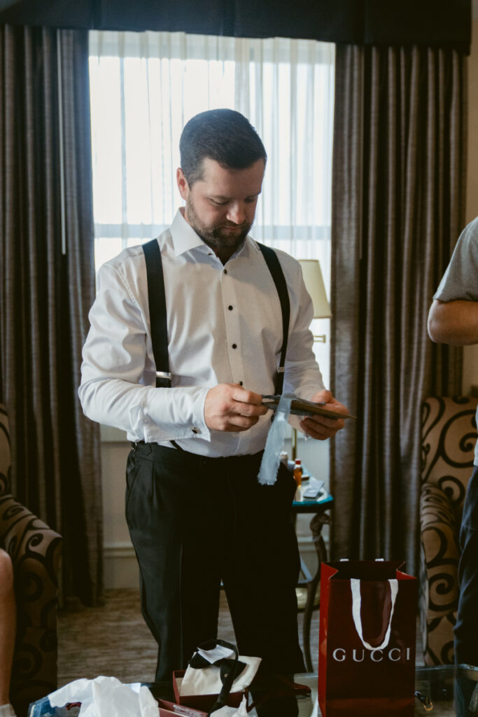 Groom preparing accessories while getting ready at a Hilton Netherland Plaza wedding.
