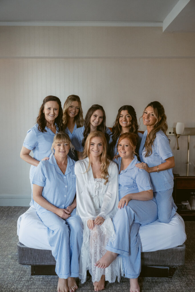 Bride with bridesmaids in matching pajamas during getting ready at a Hilton Netherland Plaza wedding.