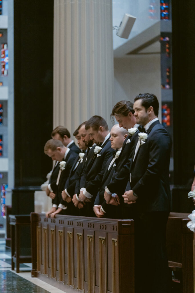 Groomsmen standing together at the front during the ceremony.