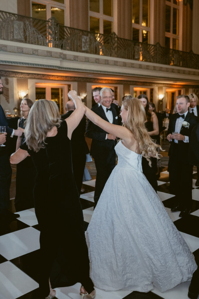 Bride dancing with a guest during a fun reception moment.