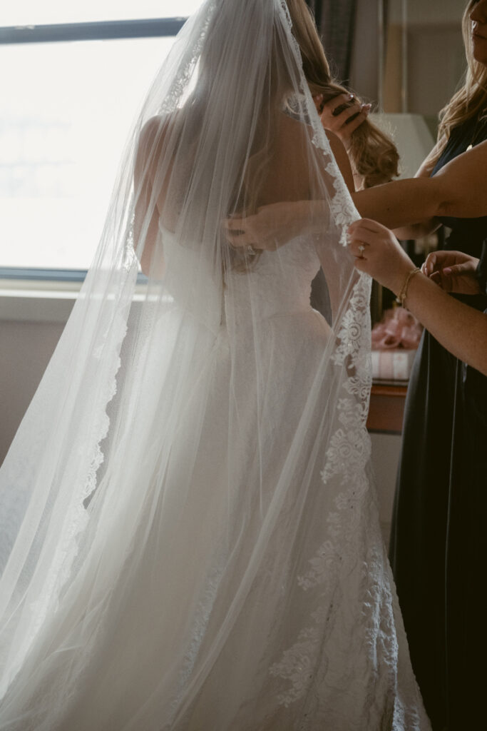 Bride having her veil placed during getting ready moments at a Hilton Netherland Plaza wedding.