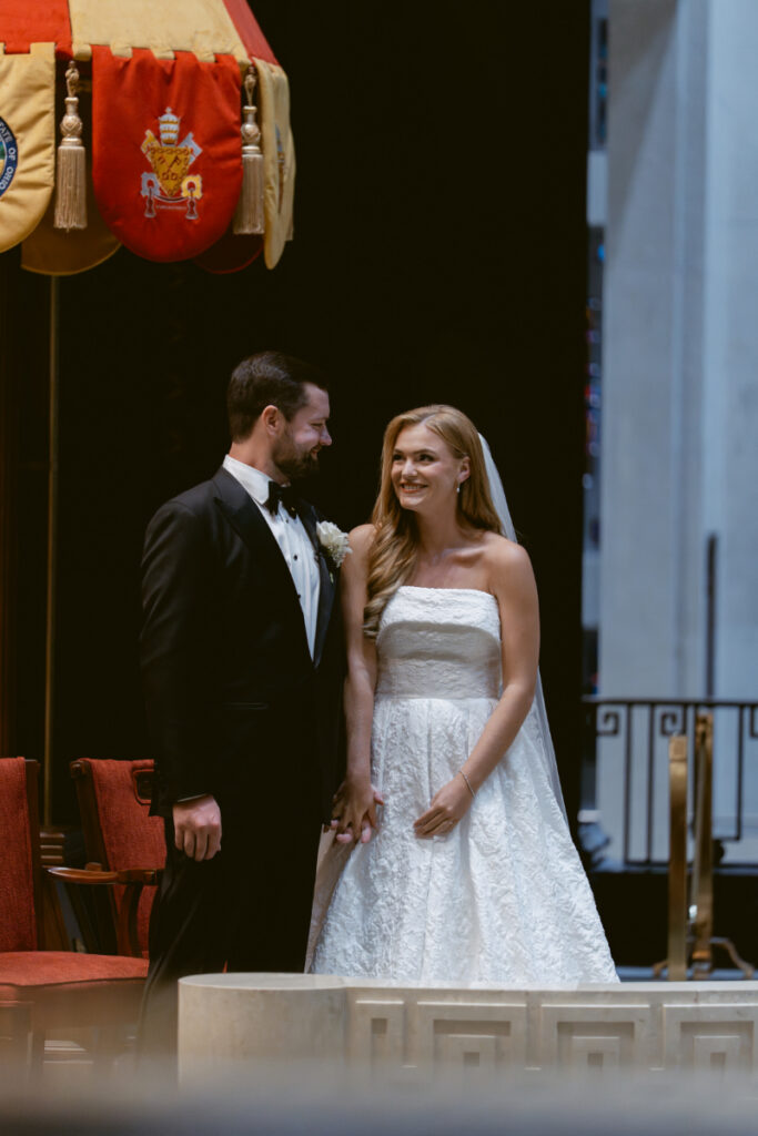 Bride and groom smiling at the altar during the ceremony.