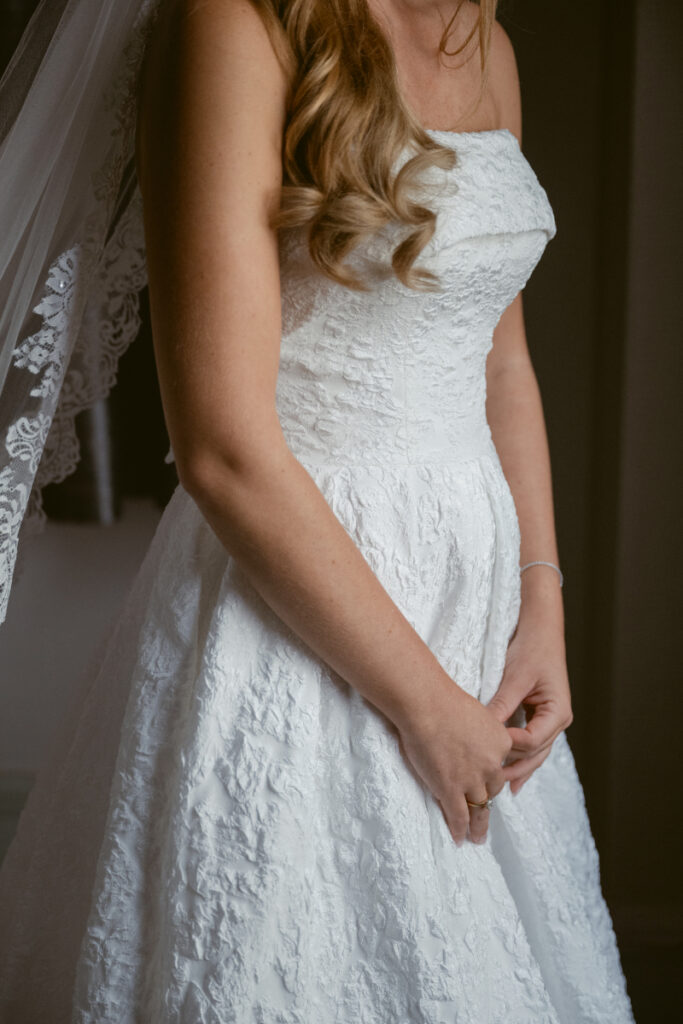 Close-up of bride’s lace wedding dress and veil during bridal portraits at a Hilton Netherland Plaza wedding.