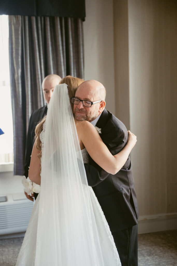 Emotional moment as bride hugs a parent during getting ready at a Hilton Netherland Plaza wedding.