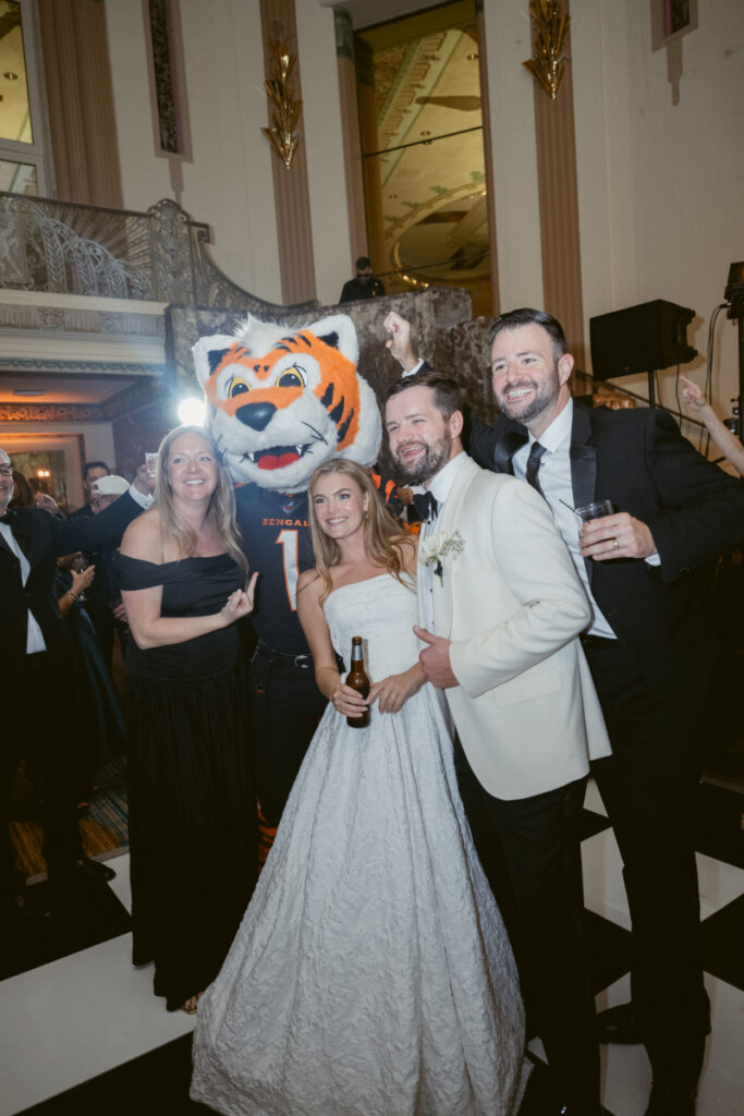 Bride and groom posing with guests on the dance floor.