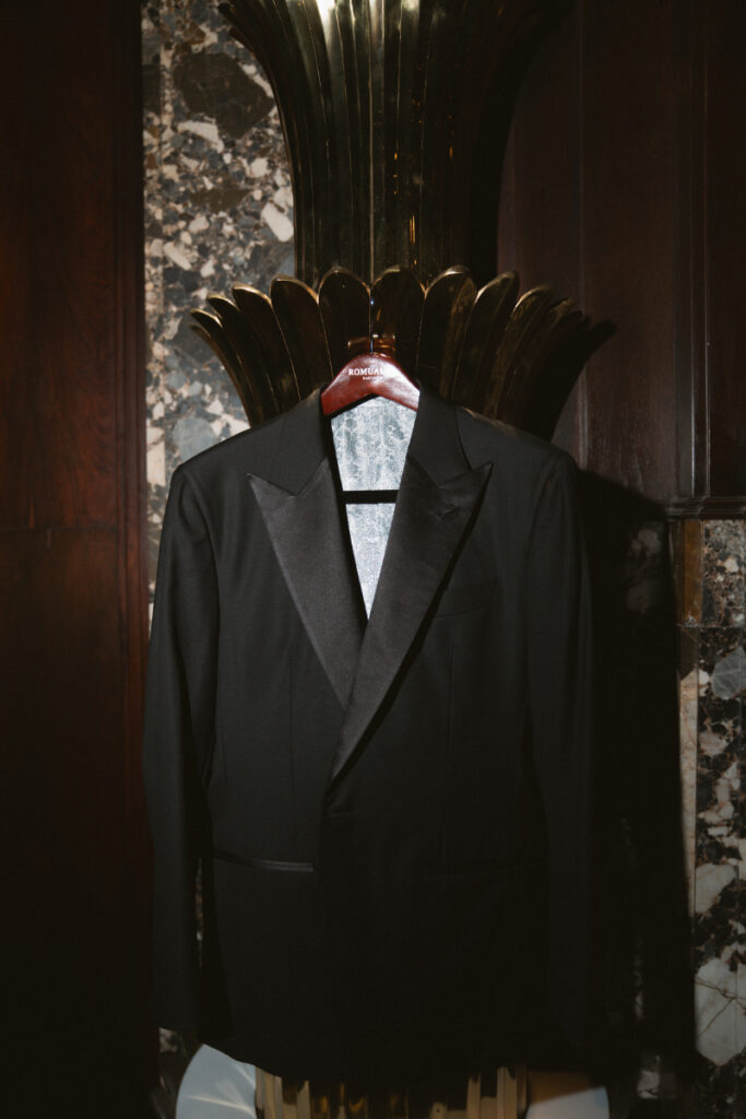 Groom’s tuxedo jacket hanging in a classic interior during a Hilton Netherland Plaza wedding.
