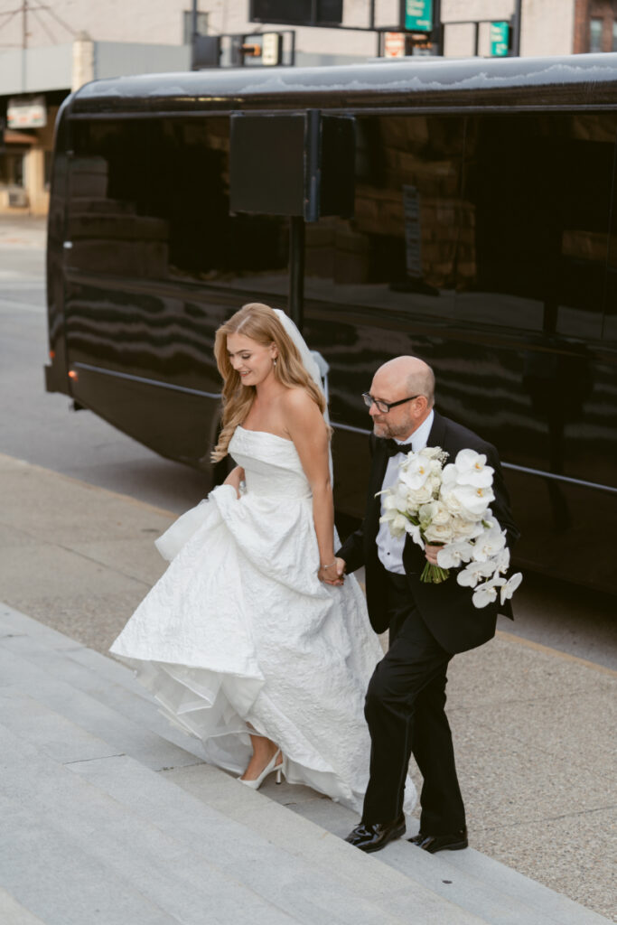 Bride walking with a parent outside the church before the ceremony at a Hilton Netherland Plaza wedding.