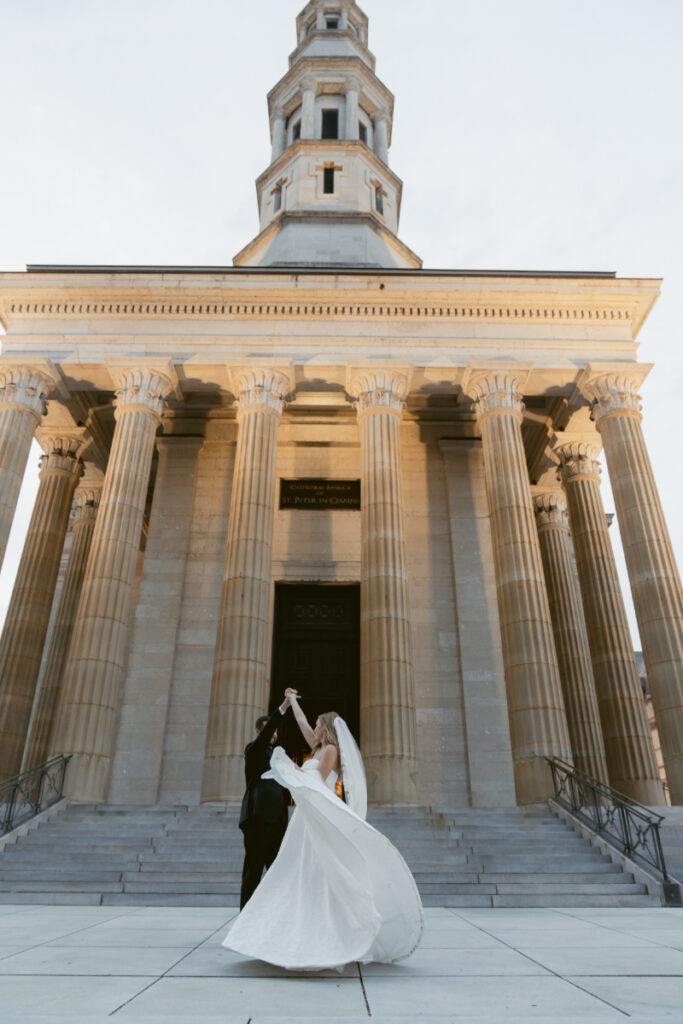 Bride and groom sharing a kiss in front of the church exterior.