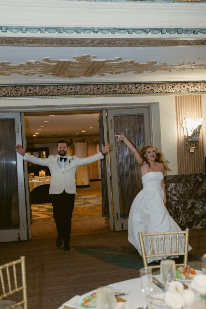 Bride and groom entering the reception with energy and excitement.