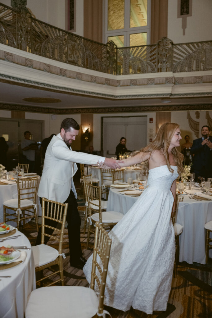 Couple laughing and dancing together during their reception entrance.