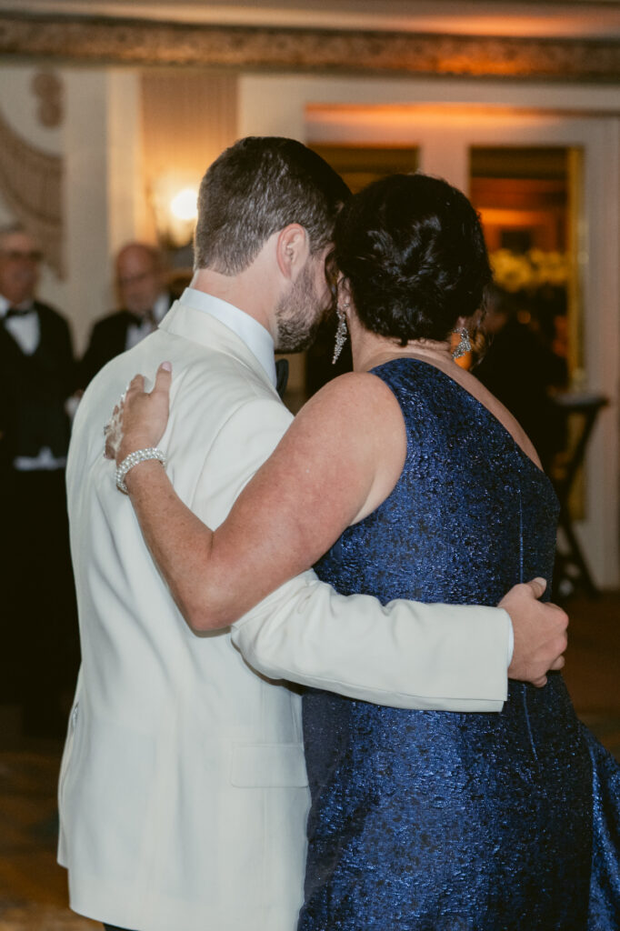 Groom hugging a guest during the reception celebration.