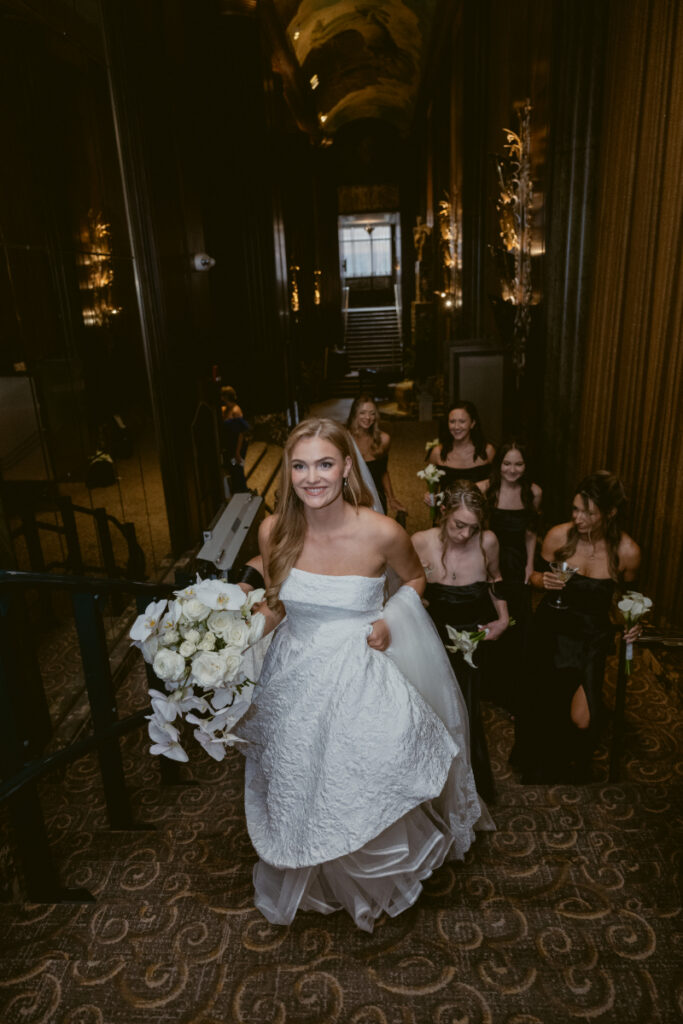 Bride with bridesmaids posing together in an elegant interior space.