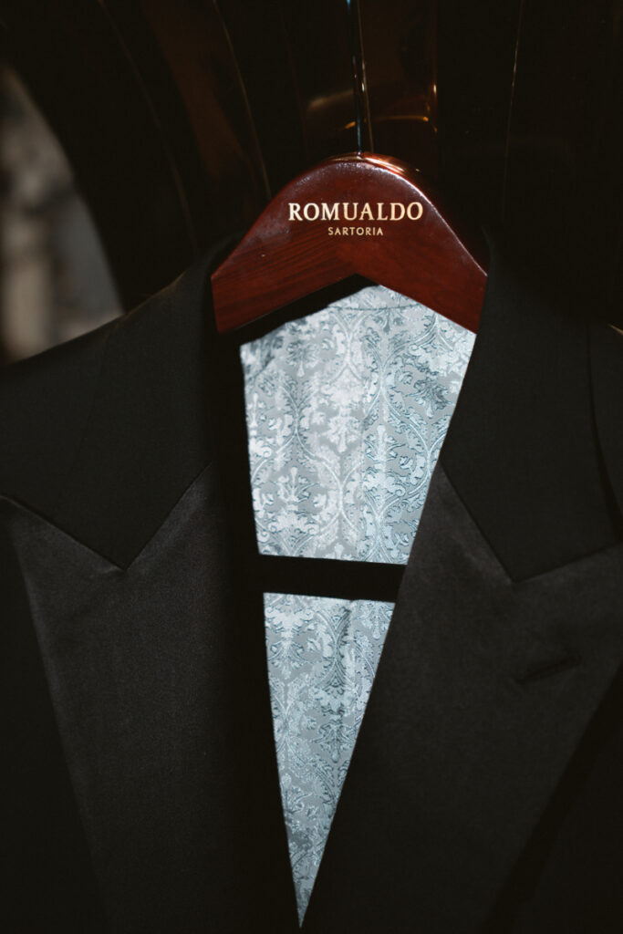 Groom tuxedo jacket with patterned vest hanging neatly, wedding checklist for groom detail shot