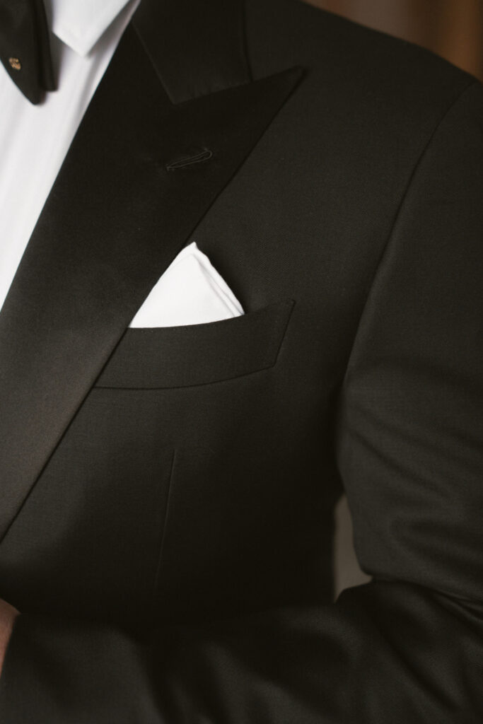 Close-up of groom suit with white pocket square, wedding checklist for groom style detail