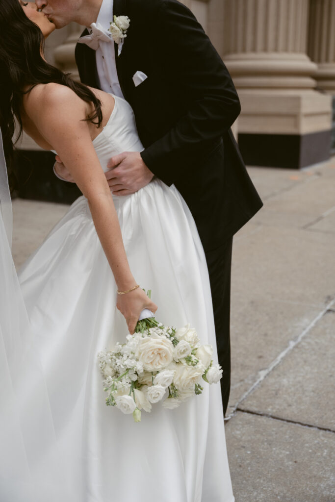 Bride and groom sharing a romantic dip pose during a wedding in Cincinnati, Ohio outside historic architecture.