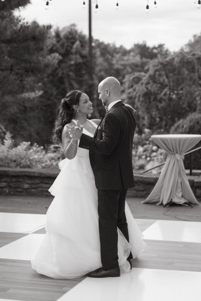 Bride and groom share their first dance during an outdoor wedding reception.