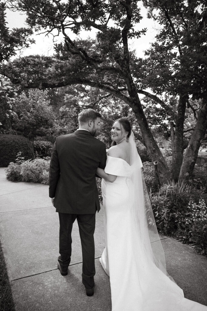 Bride and groom stroll along a garden path at one of Cincinnati's peaceful garden wedding venues.