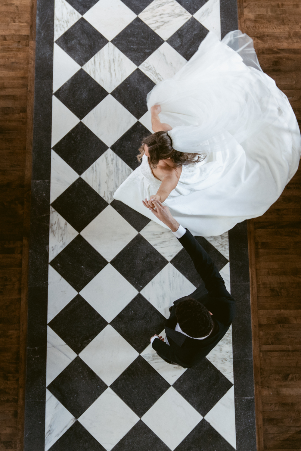 Bride and groom share a dramatic overhead first look portrait on The Palomar's iconic black and white marble floor.