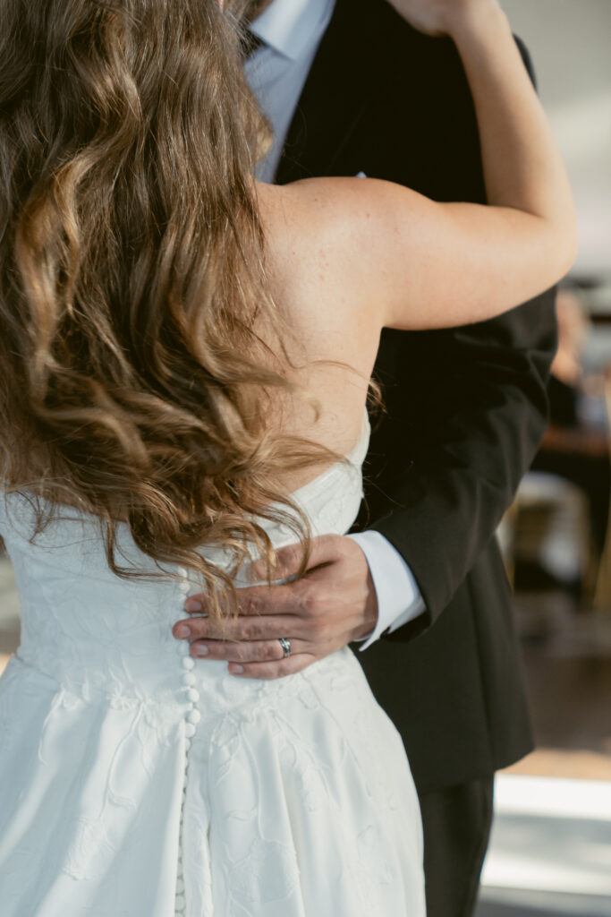Close up of the groom holding his bride during their romantic first dance.