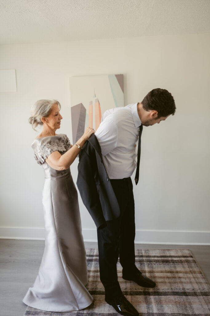 Groom's mother helps him with his jacket before the ceremony at one of Ohio wedding venues.
