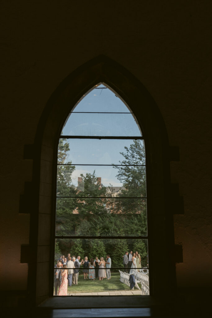 Guests gather outside The Palomar before the ceremony, viewed through the venue's iconic window at one of Ohio wedding venues.