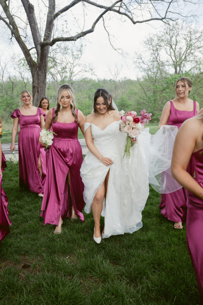 Bride and bridesmaids walk across the lawn together before the wedding ceremony.